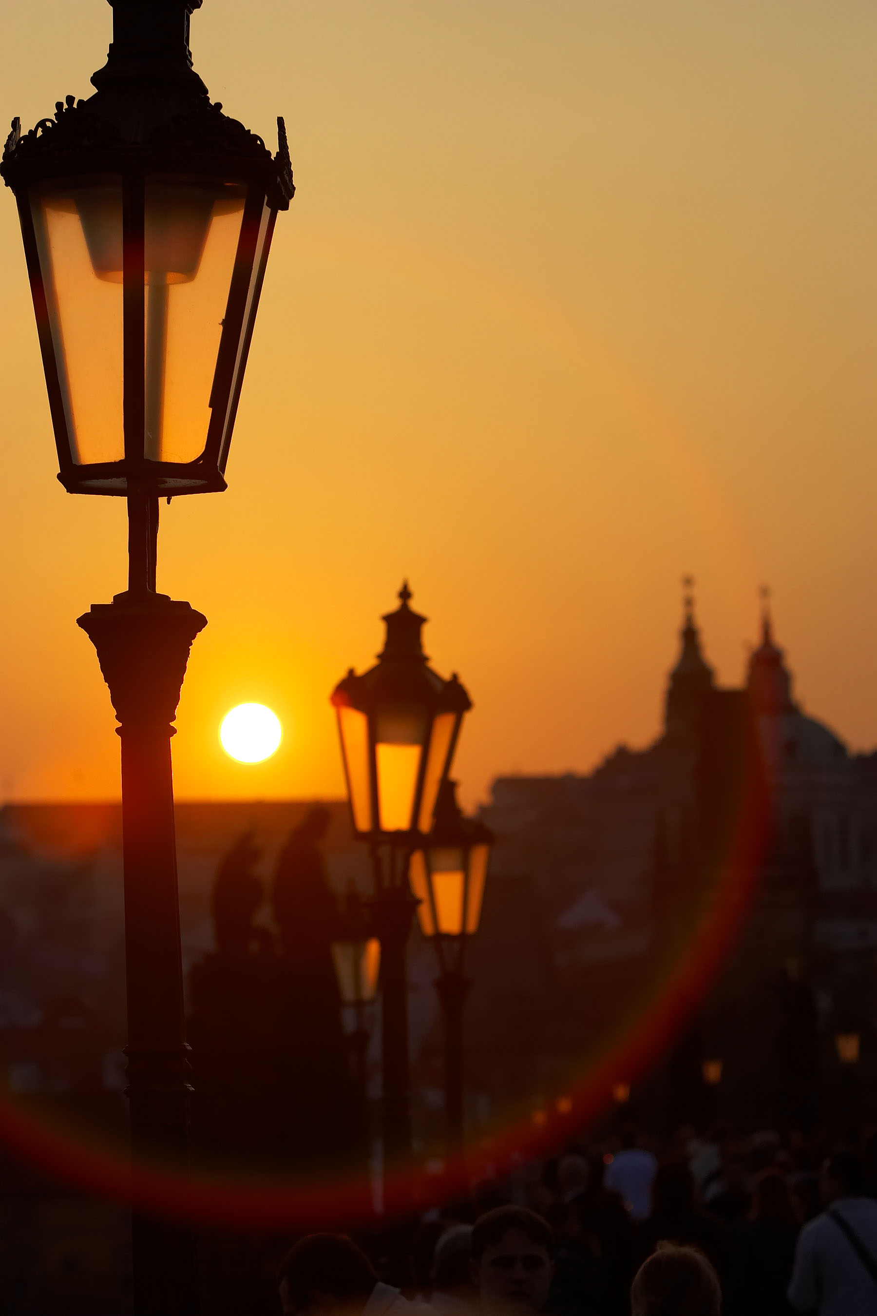 Lamp at dusk on the Charles Bridge over the Vlatva River in Prague, Czech Republic with Prague Castle in background